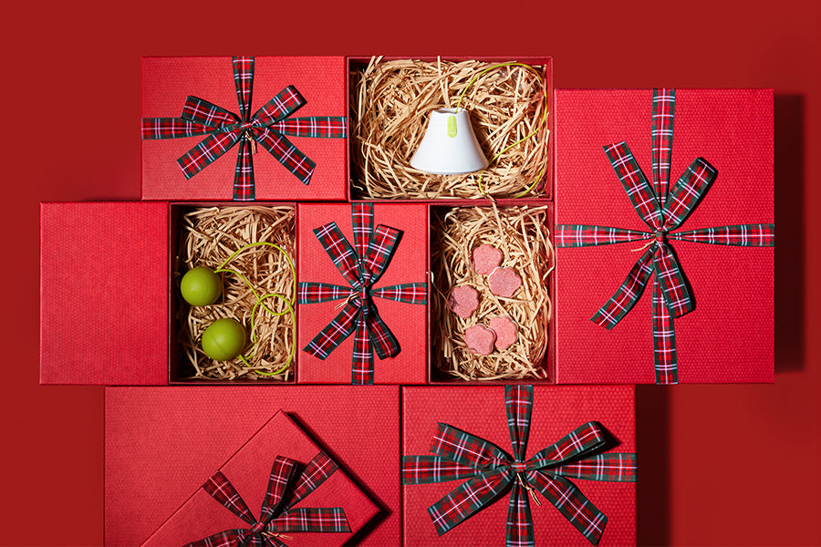 Hand holding a white dishwasher tablet against a blue sky background
